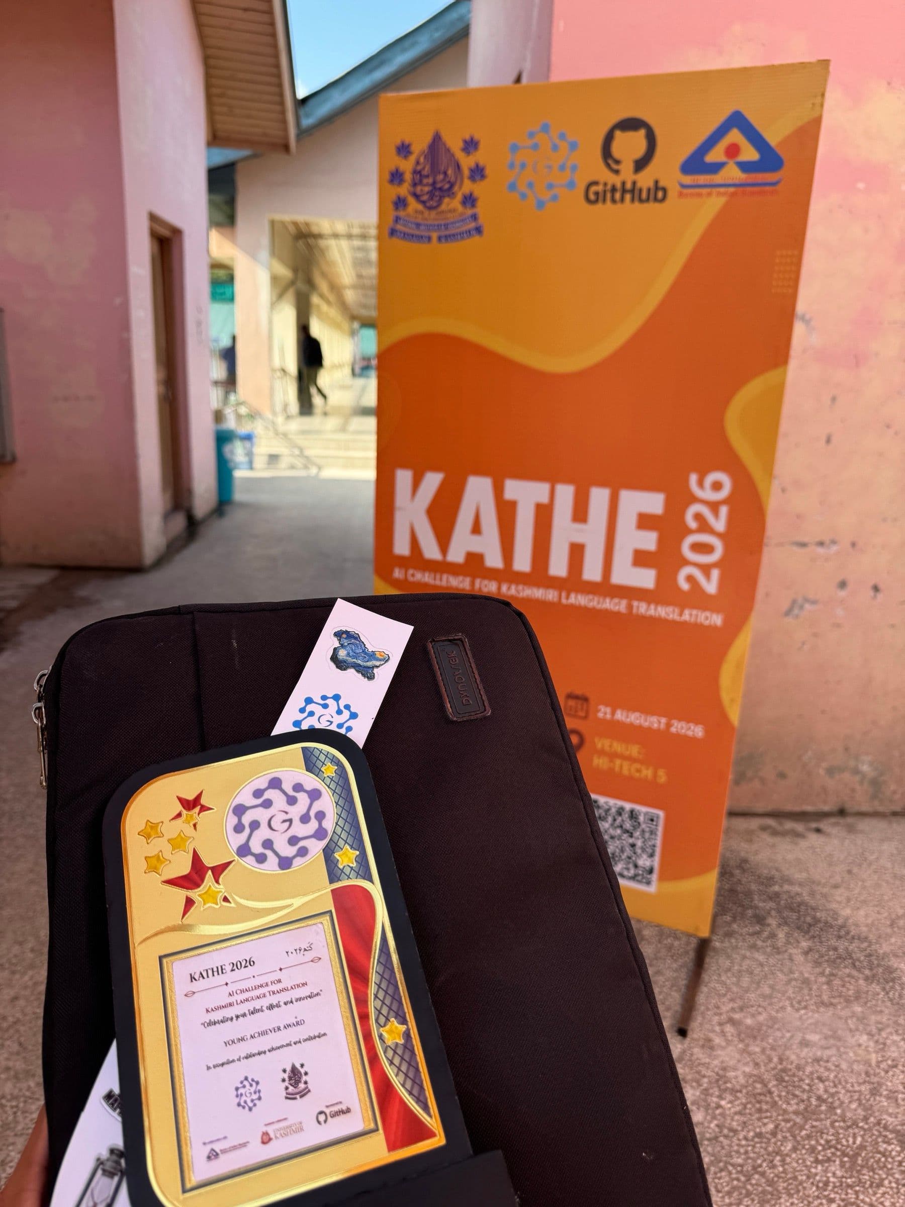 The Young Achiever Award plaque on a laptop sleeve, in front of a KATHE 2026 banner
